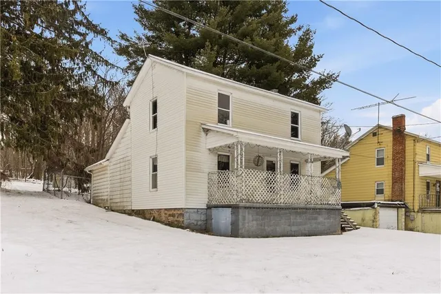 a view of a white house with a large tree