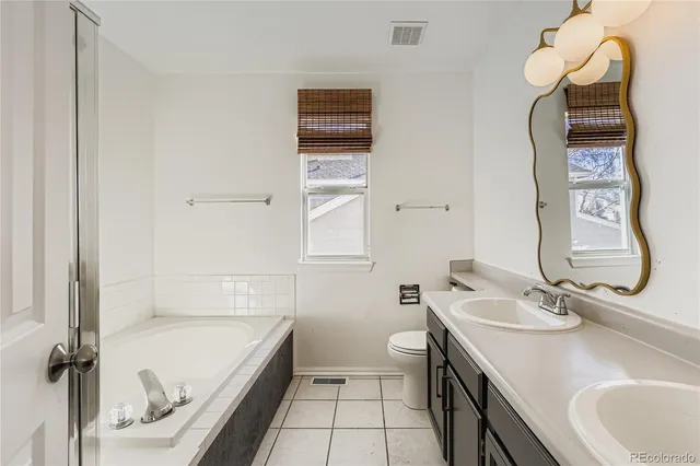 a bathroom with a granite countertop toilet sink and mirror