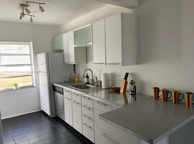 a kitchen with stainless steel appliances granite countertop a sink a stove and a refrigerator