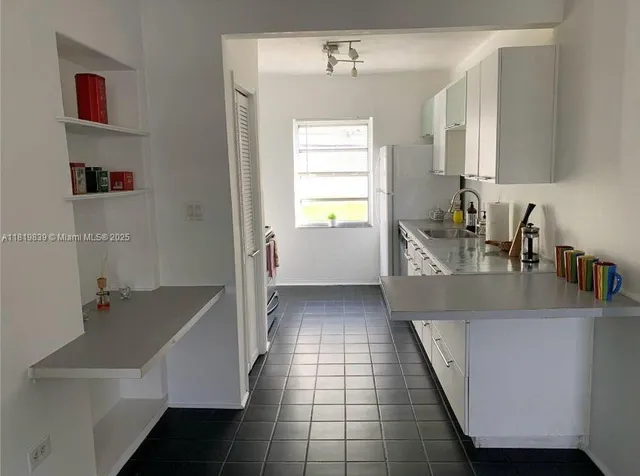a kitchen with a sink a counter top space and cabinets