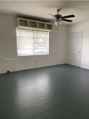 en empty room with windows and ceiling fan