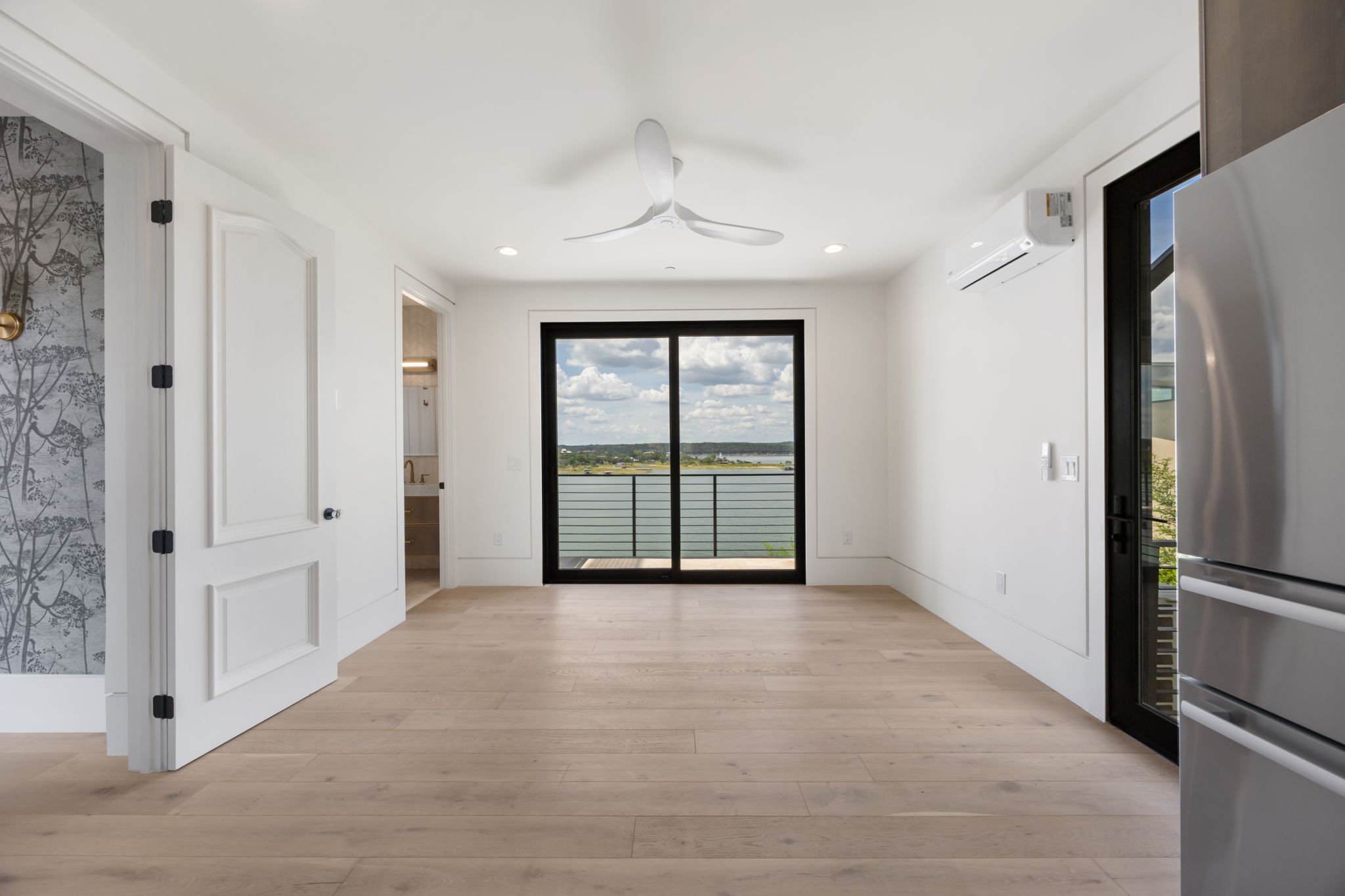 1496 Buffalo Gap Road Lakeway, TX 78734 - Photo 15 of 37 Hardwood floors and a wide sliding glass door define this airy room, providing tranquil views of the waterfront.