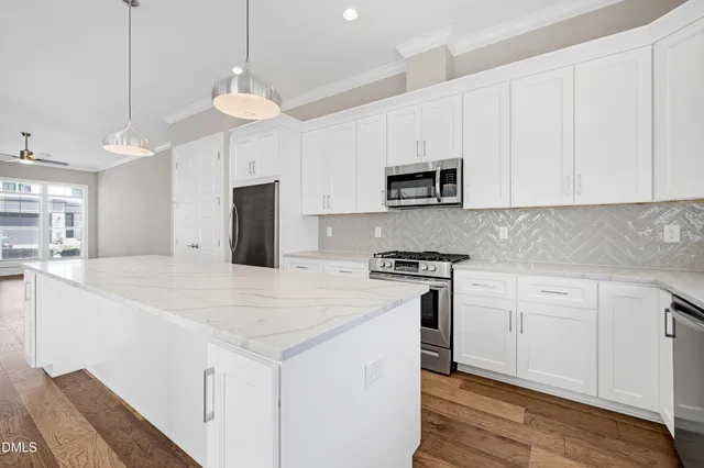 a kitchen with stainless steel appliances granite countertop a stove a sink and a refrigerator
