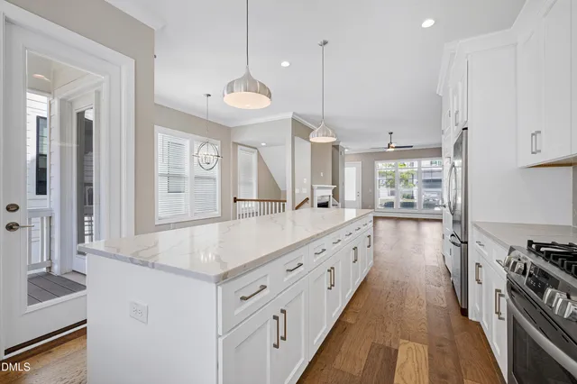a kitchen with stainless steel appliances granite countertop a sink a stove and a wooden floors