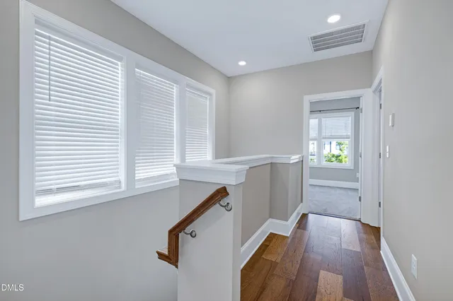a view of a hallway with wooden floor and staircase