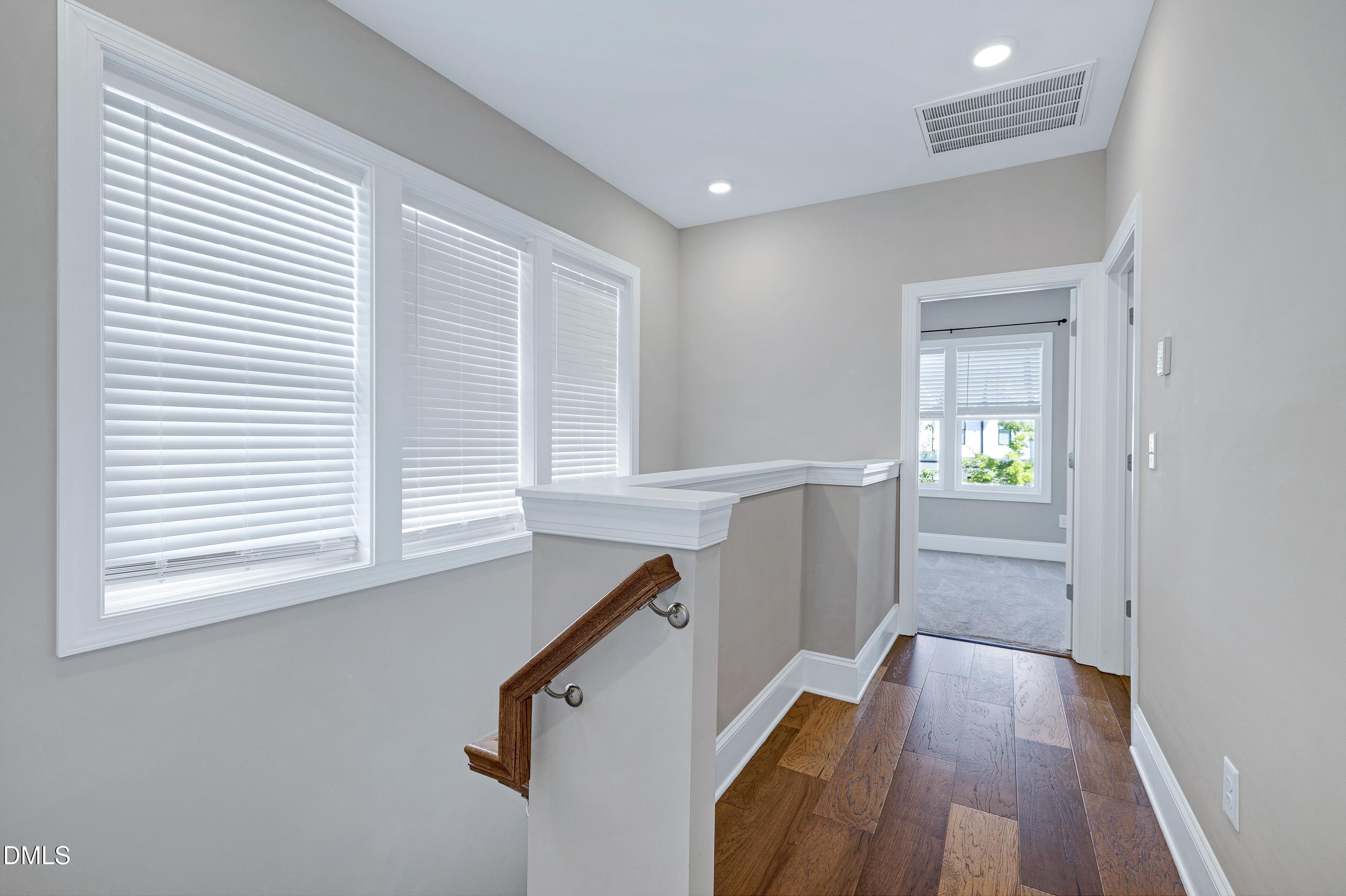 4909 Madone Drive Raleigh, NC 27606 - Photo 18 of 48 a view of a hallway with wooden floor and staircase