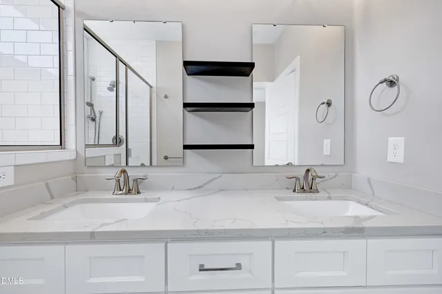 a bathroom with double vanity sinks and a mirror
