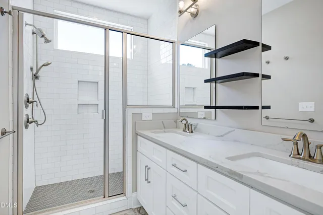 a bathroom with a double vanity sink mirror and shower