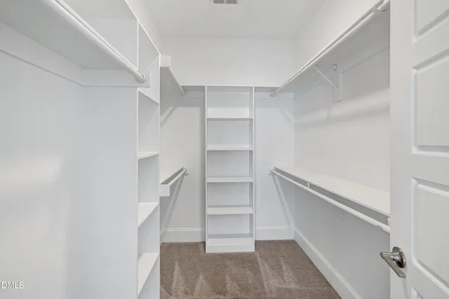 a view of walk in closet with empty racks