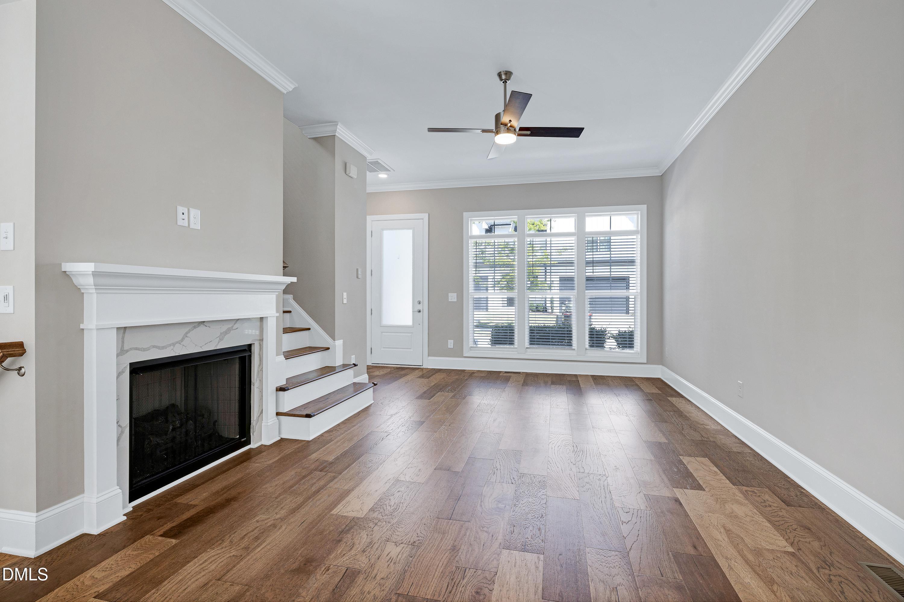 4909 Madone Drive Raleigh, NC 27606 - Photo 6 of 48 a view of an empty room with wooden floor fireplace and a window