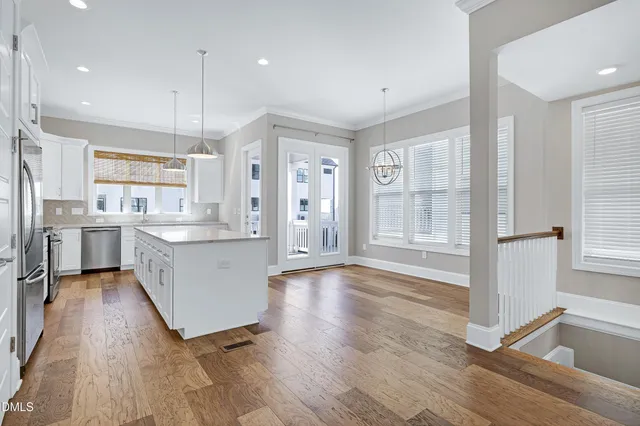 a large kitchen with stainless steel appliances a large counter top and a wooden floors