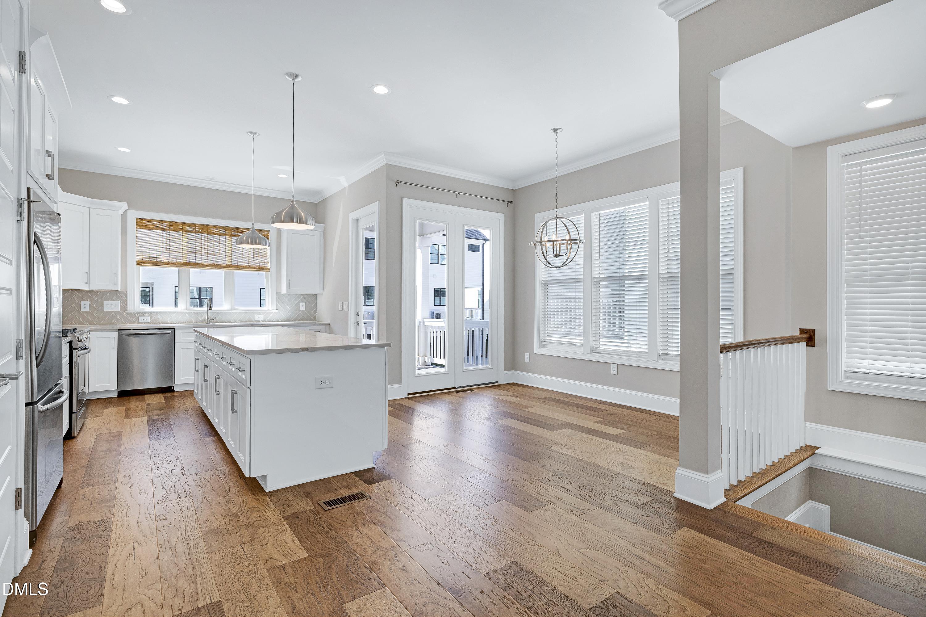 4909 Madone Drive Raleigh, NC 27606 - Photo 7 of 48 a large kitchen with stainless steel appliances a large counter top and a wooden floors