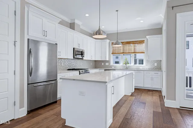 a kitchen with kitchen island white cabinets and stainless steel appliances