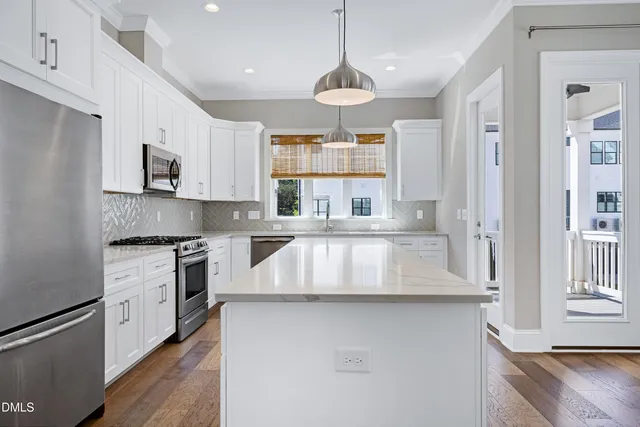 a kitchen with stainless steel appliances granite countertop a sink a stove and a refrigerator