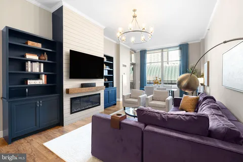 a kitchen with stainless steel appliances granite countertop a microwave a stove and white cabinets with wooden floor