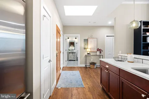 a kitchen with stainless steel appliances cabinets and a wooden floor