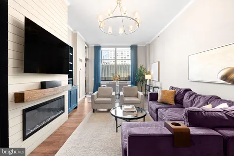 a living room with couch a fireplace and a chandelier