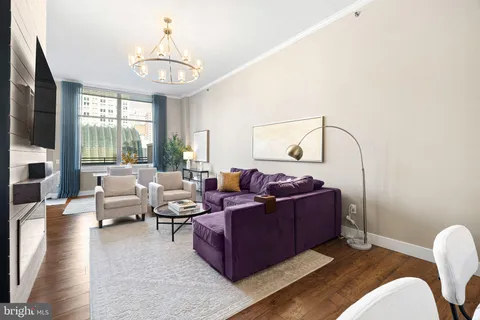 a living room with furniture ceiling fan and a flat screen tv
