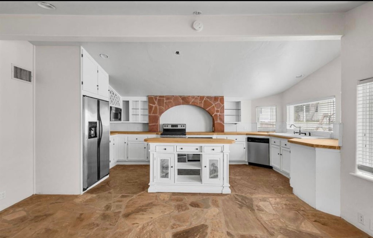 251 Circle Drive Wimberley, TX 78676 - Photo 18 of 32 a kitchen with stainless steel appliances granite countertop a stove top oven sink and cabinets