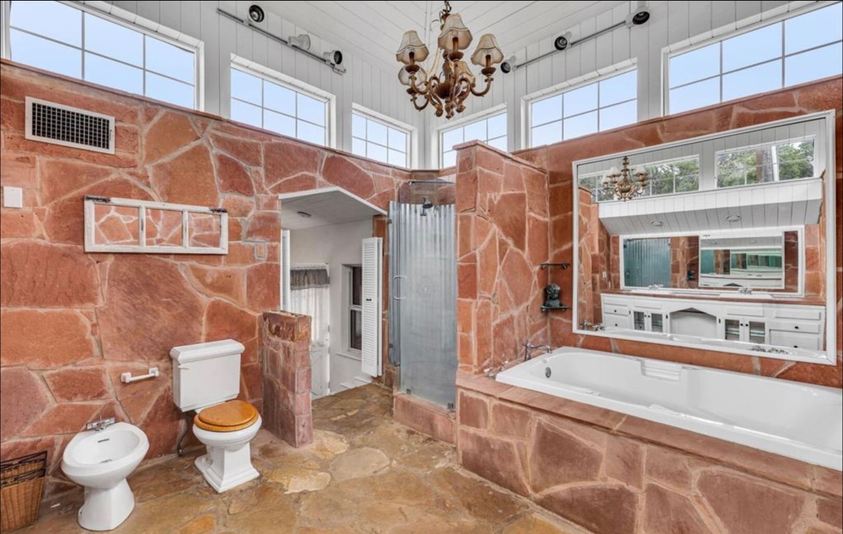 251 Circle Drive Wimberley, TX 78676 - Photo 21 of 32 a bathroom with a granite countertop toilet a sink and a bathtub