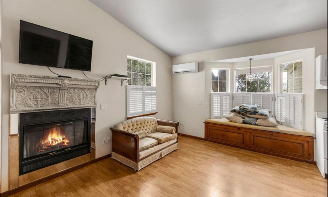 251 Circle Drive Wimberley, TX 78676 - Photo 24 of 32 a living room with furniture a fireplace and a flat screen tv