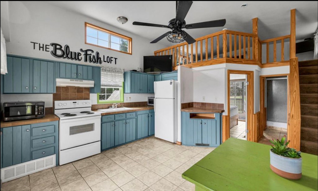 251 Circle Drive Wimberley, TX 78676 - Photo 26 of 32 a kitchen with a refrigerator and a stove top oven