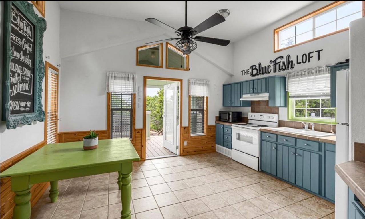 251 Circle Drive Wimberley, TX 78676 - Photo 27 of 32 a kitchen with stainless steel appliances kitchen island granite countertop a table chairs in it and wooden floors
