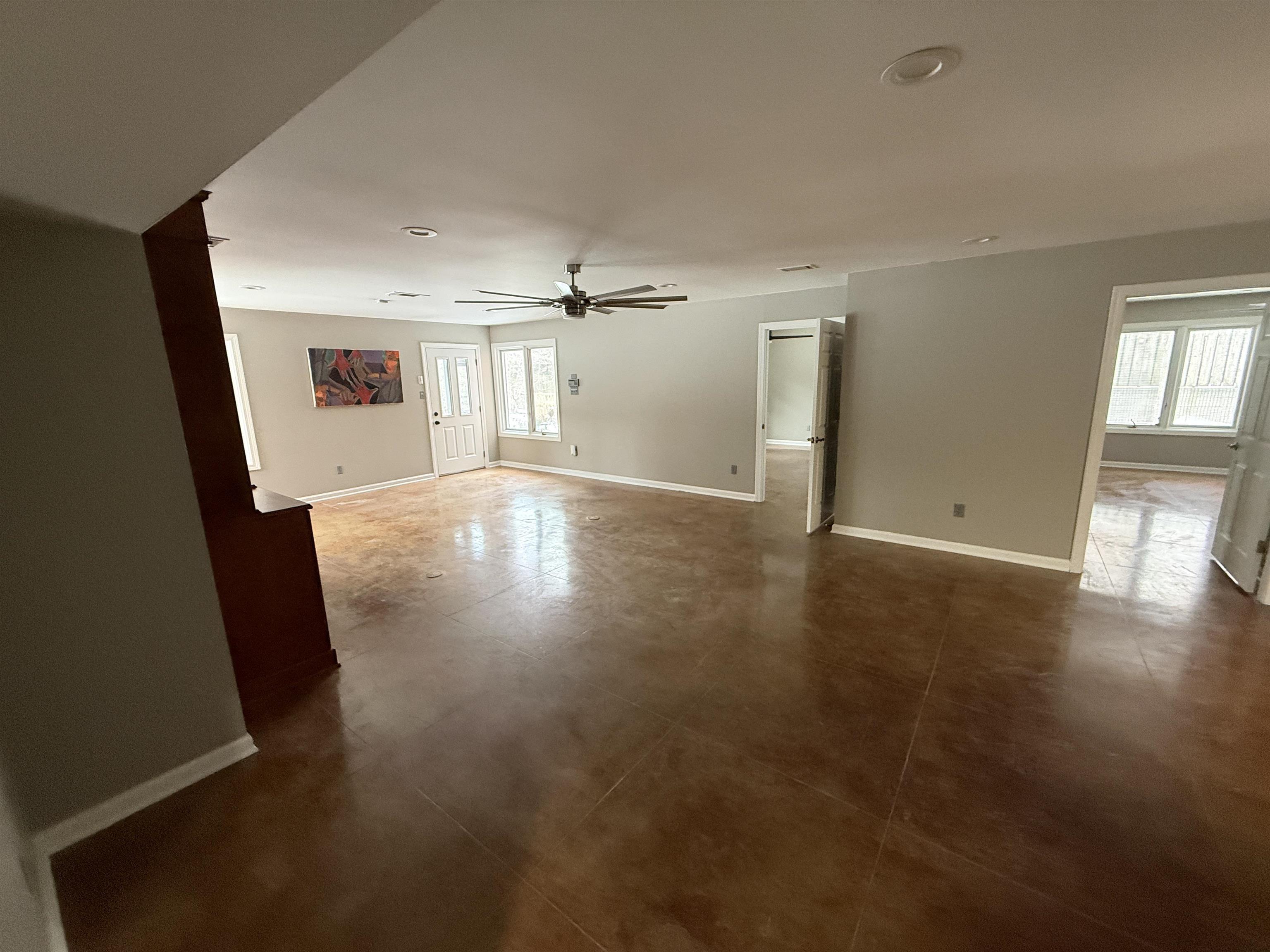 765 Sweetbrier Road Memphis, TN 38120 - Photo 20 of 33 Unfurnished living room with ceiling fan and concrete flooring