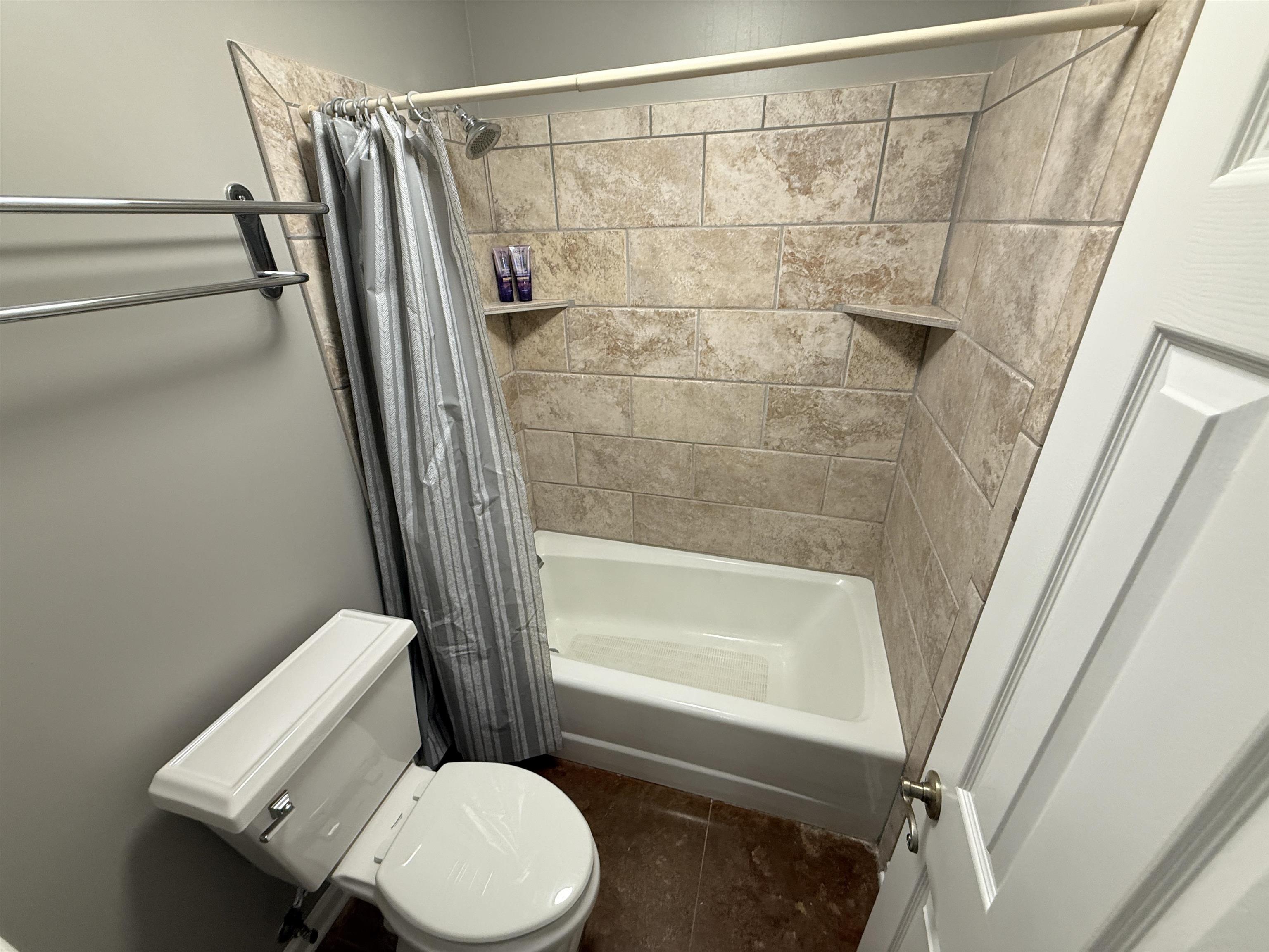 765 Sweetbrier Road Memphis, TN 38120 - Photo 28 of 33 Full bathroom featuring shower / bathtub combination with curtain and dark tile patterned floors