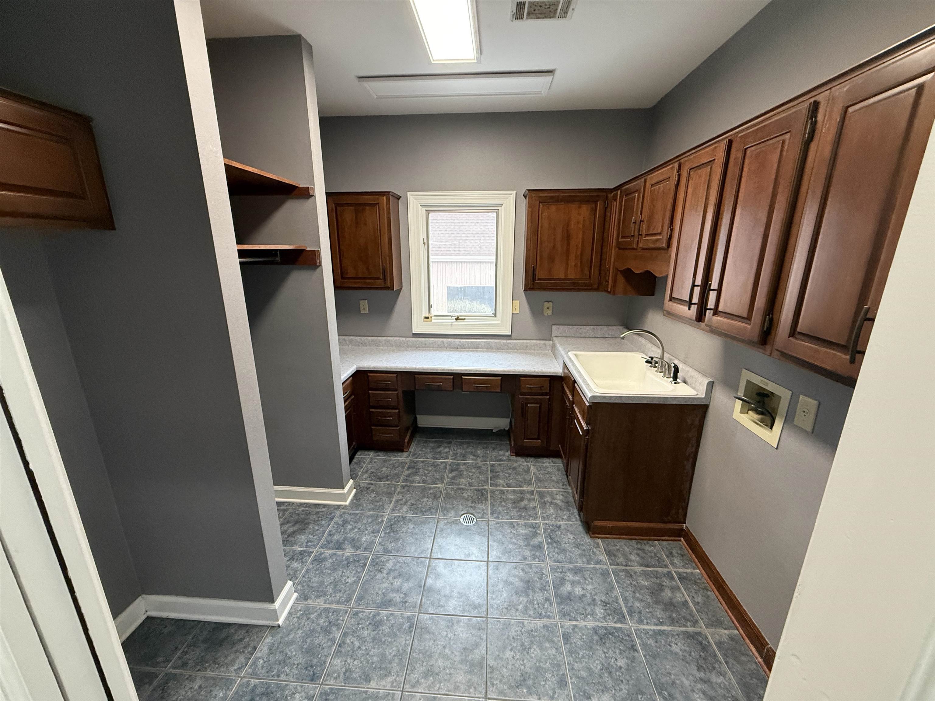 765 Sweetbrier Road Memphis, TN 38120 - Photo 3 of 33 Laundry area featuring cabinet space, washer hookup, and dark tile patterned floors