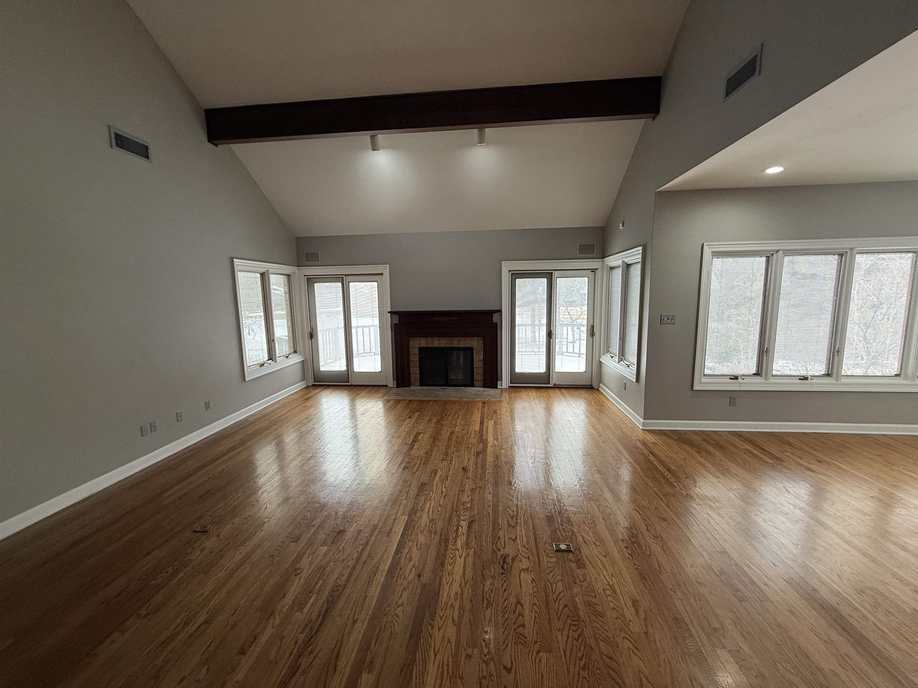 765 Sweetbrier Road Memphis, TN 38120 - Photo 9 of 33 Unfurnished living room featuring dark wood-type flooring, a fireplace, and lofted ceiling