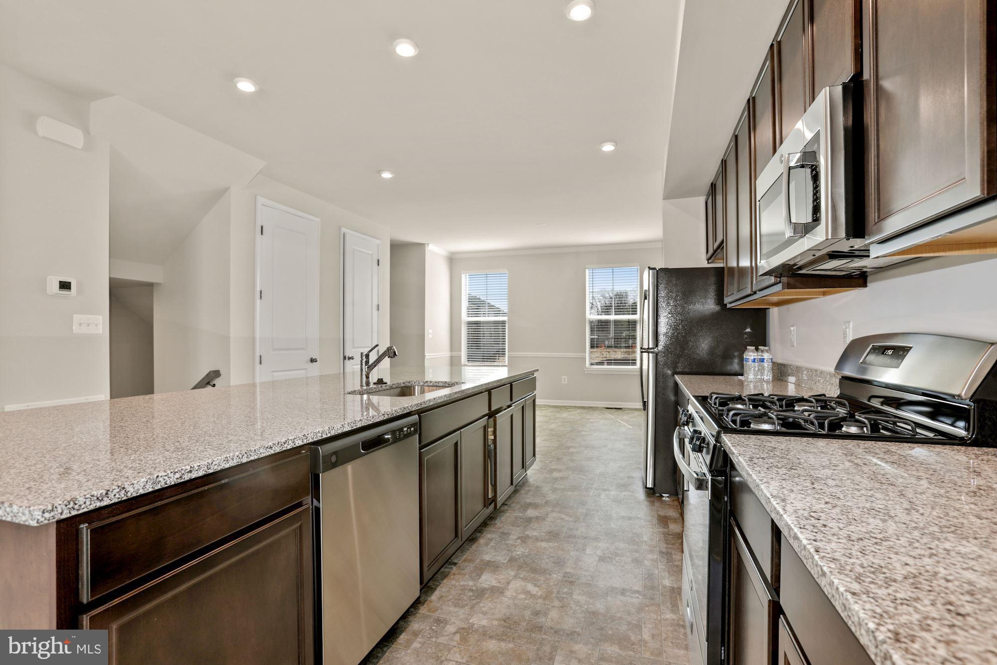 3970 Shire Meadow Lane Triangle, VA 22172 - Photo 12 of 52 a kitchen with stainless steel appliances granite countertop a sink a stove and a refrigerator