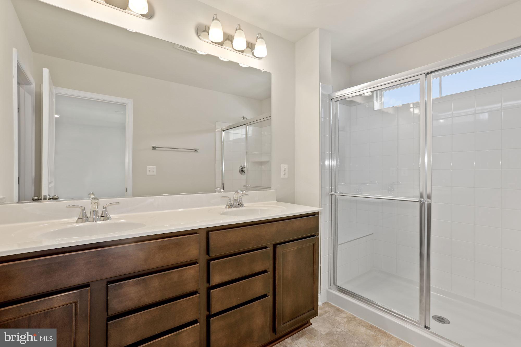 3970 Shire Meadow Lane Triangle, VA 22172 - Photo 42 of 52 a bathroom with a double vanity sink mirror and shower