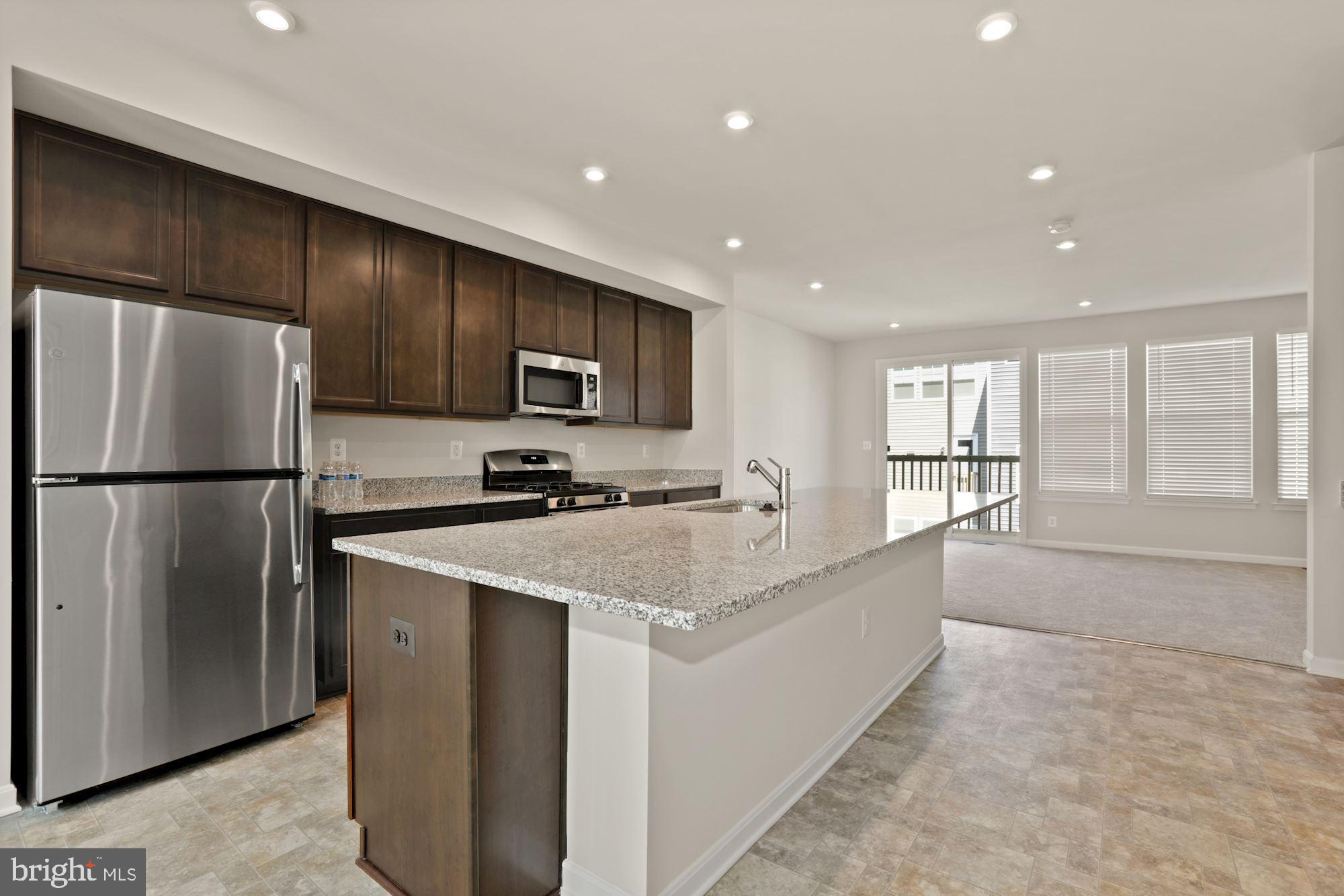 3970 Shire Meadow Lane Triangle, VA 22172 - Photo 9 of 52 a large kitchen with stainless steel appliances granite countertop a refrigerator a sink a stove and oven