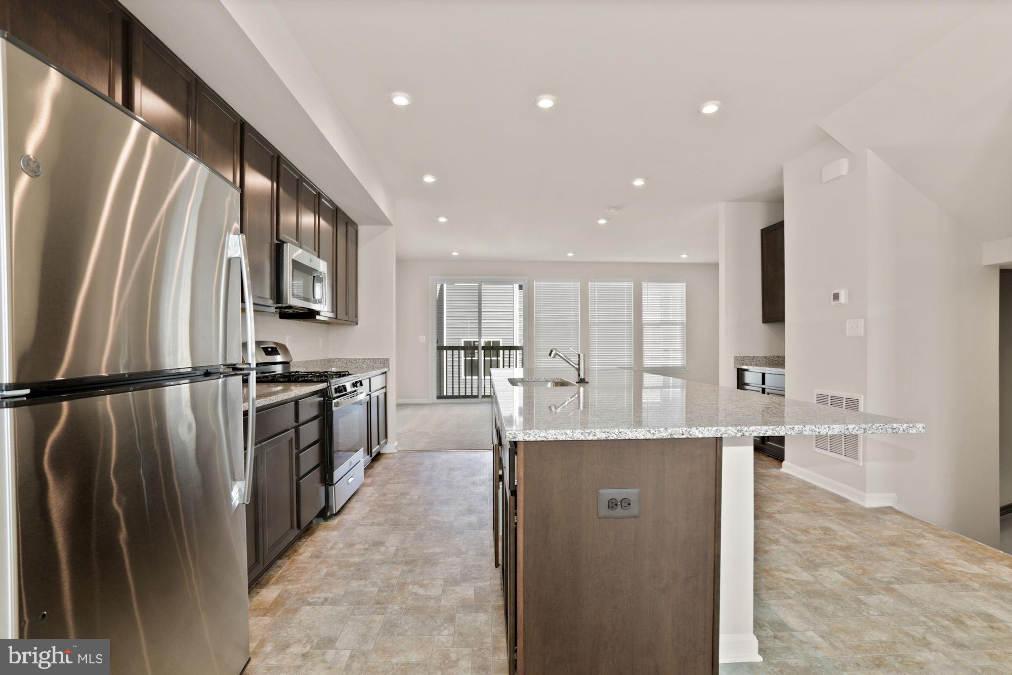 3970 Shire Meadow Lane Triangle, VA 22172 - Photo 10 of 52 a kitchen with stainless steel appliances granite countertop a refrigerator a sink a stove and a refrigerator