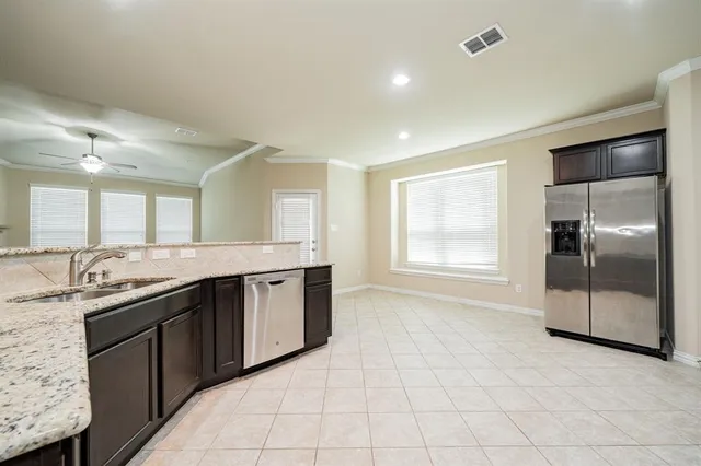 a large kitchen with granite countertop a sink and cabinets