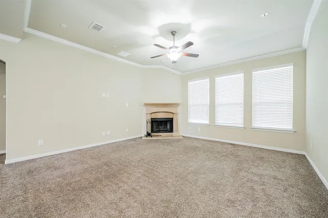 an empty room with windows and fireplace