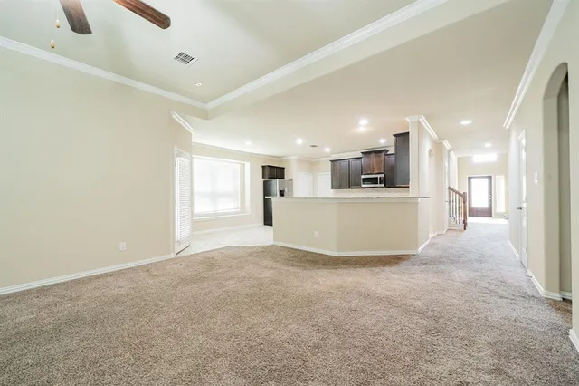 an empty room with windows and ceiling fan