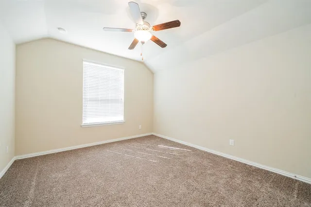 an empty room with a window and a ceiling fan