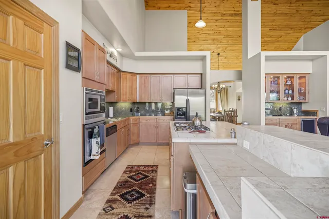a kitchen with stainless steel appliances granite countertop a stove a sink and a refrigerator