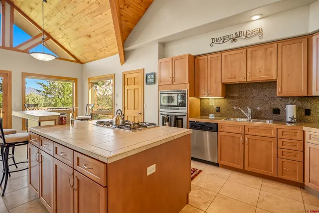a kitchen with stainless steel appliances granite countertop a stove a sink dishwasher and a refrigerator