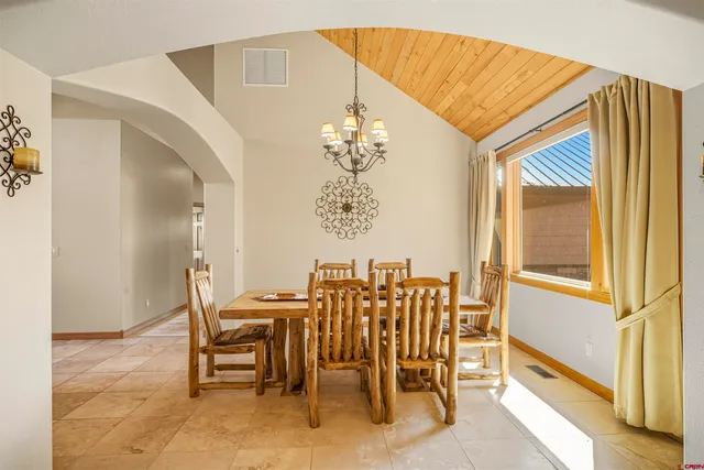 a view of a dining room with furniture and a chandelier