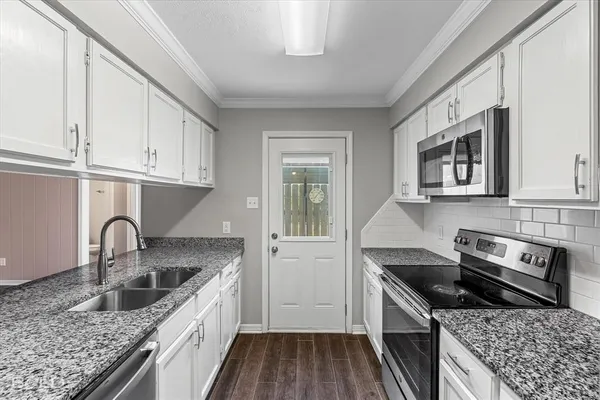a kitchen with stainless steel appliances granite countertop a sink stove and cabinets