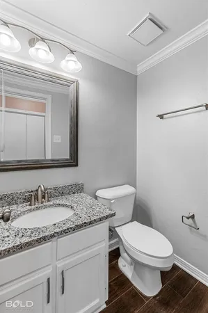 a bathroom with a granite countertop toilet sink and mirror