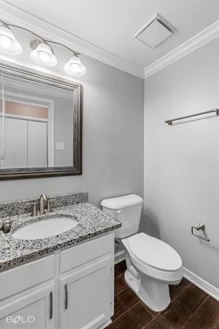 a bathroom with a granite countertop toilet sink and mirror