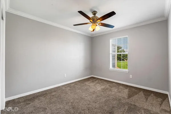 an empty room with window and ceiling fan