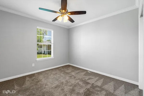 an empty room with a window and a fan