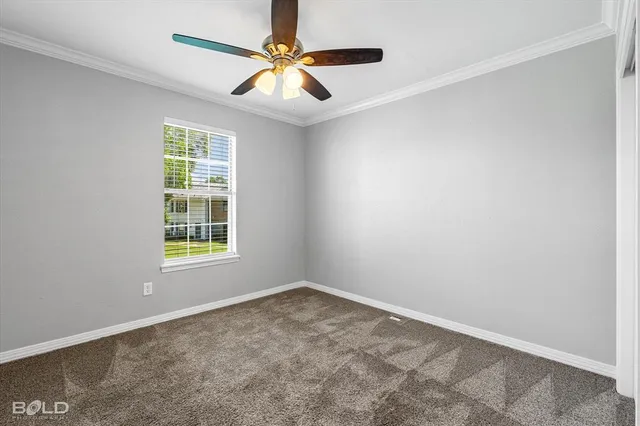an empty room with a window and a fan