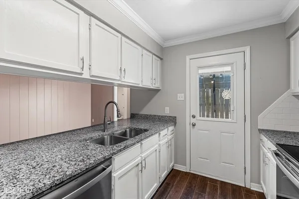 a kitchen with granite countertop a sink and a stove