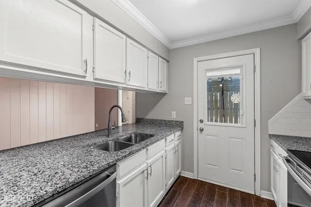 a kitchen with granite countertop a sink and a stove